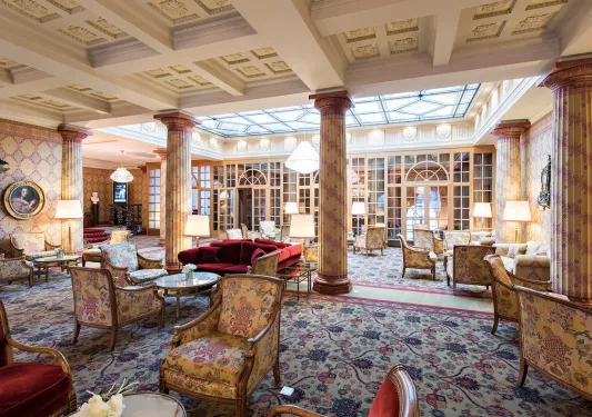 Indoor lobby and lounge with cushioned chairs and giant stone pillars