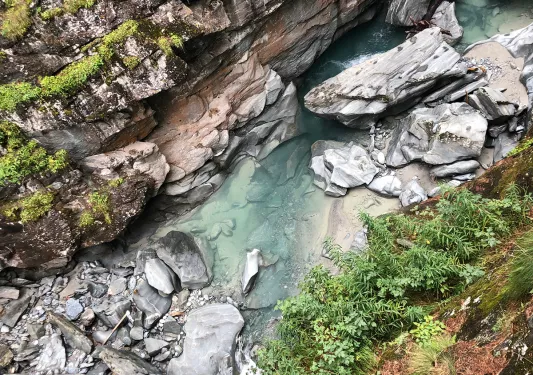Sky view of river with large, jagged rocks and boulders