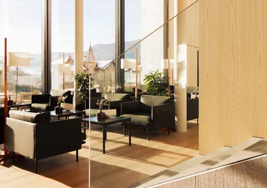 Hotel lounge with large windows and a glass staircase to the right