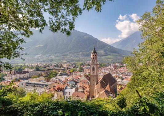Wide view of a rustic town with a clock tower and white buildings in the center