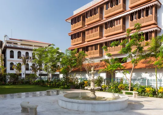 Exterior view of multi-level hotel building with a fountain in front