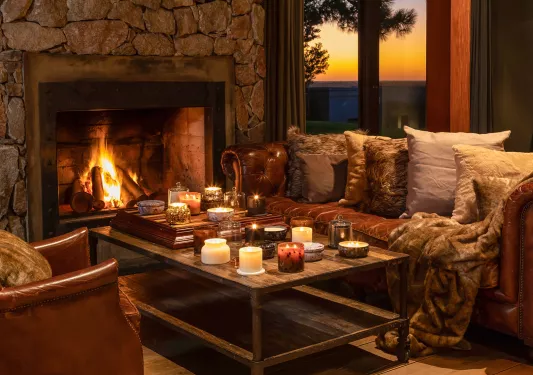 Cozy room with couches and a coffee table in front of a stone fireplace