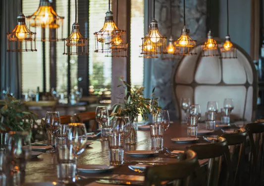 Dining hall with a large wooden dining table and glasses of water