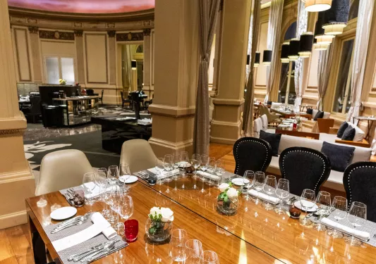 Dining hall area with wooden tables and wine glasses on each table