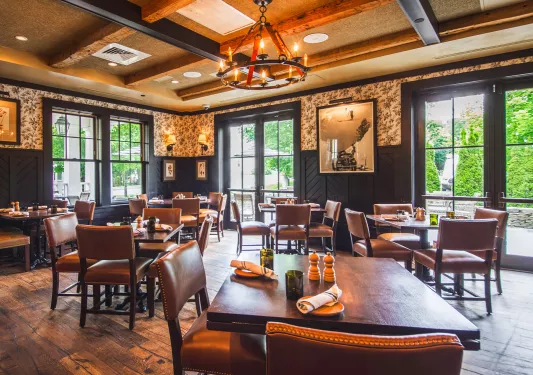 Hotel restaurant with wooden tables and chairs, with large windows