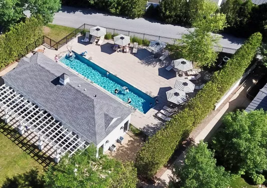 Sky view of gray building with an outdoor pool to the right