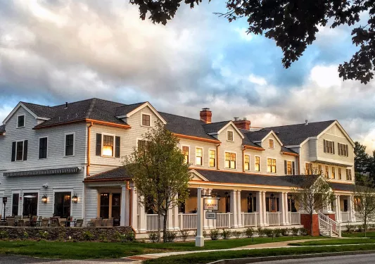 Exterior view of long, gray building with trimmed grass around sidewalks