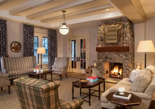 Lounge and seating area with cushioned chairs in front of a fireplace