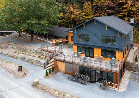 Gray and brown wooden building with an outdoor patio and bikes parked out front