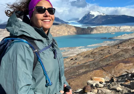 Woman smiling while ascending a rocky hill