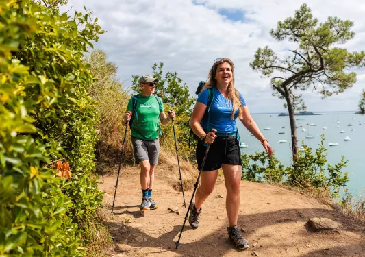 Man and woman smiling while walking through a dirt trail