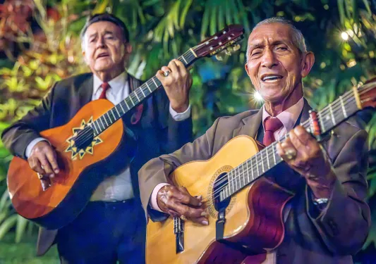 Two men playing guitars and singing