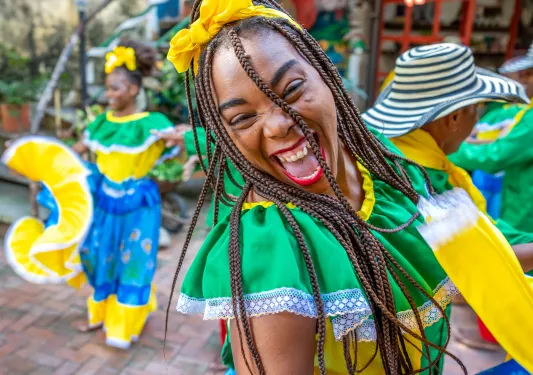 Group of women wearing traditional dresses dancing in a town square