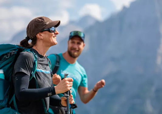 Woman smiling while walking with hiking poles