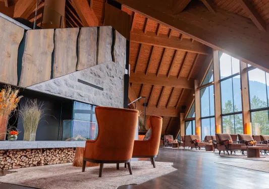 Indoor lounge and seating area with two leather chairs in front of a fireplace