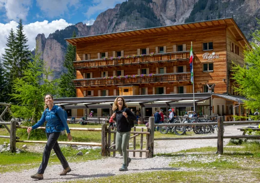 Exterior view of wooden hotel building with two women in front walking