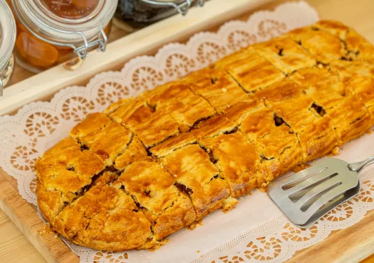 Large baked pastry with a silver spatula to the right