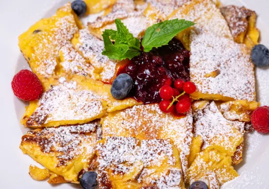 White plate with strudel and fruits on top