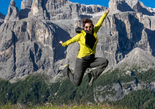 Woman jumping with views of large mountains in the background
