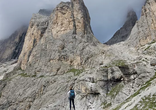 Person looking up to large mountains