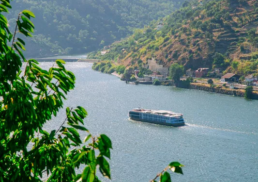 Large boat on a fiver with mountains on either side