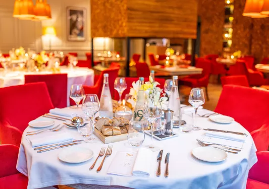 Circular dining table with silverware and a flower centerpiece