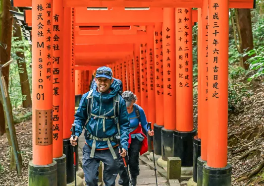 Man and woman smiling while walking along a Japanese shrine