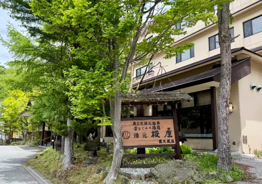 Exterior view of a beige, colored building with a Japanese sign in front