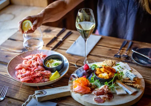 Plate with boiled seafood, with a charcuterie board next to it