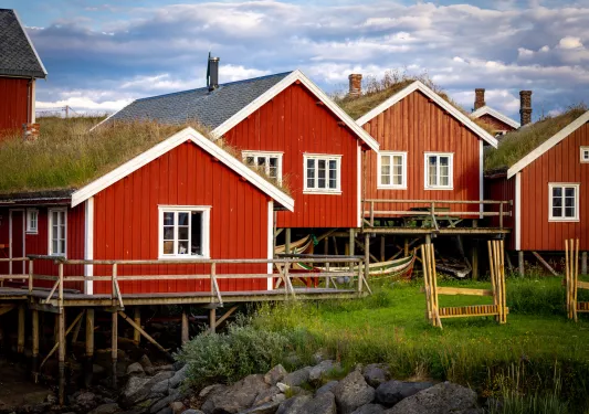 Cluster of red cabin buildings next to a river