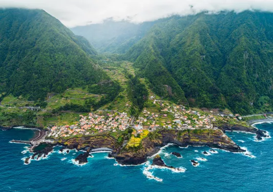 Sky view of a coastal town by large cliffs, next to the ocean