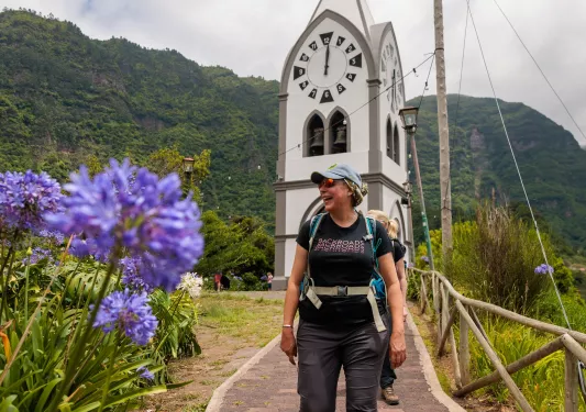 Woman smiling, with a large church clocktower in the background