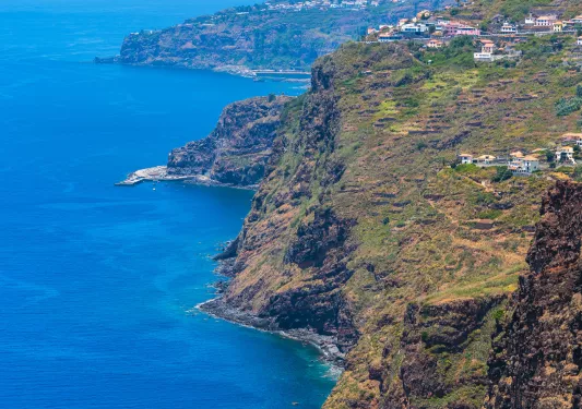 Large cliff, with the ocean on the ground floor and houses on the cliff