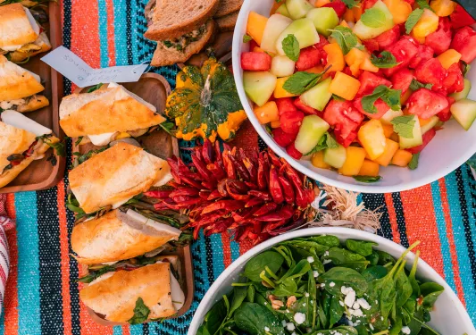 Colorful table with sandwiches and fruit salad in a bowl