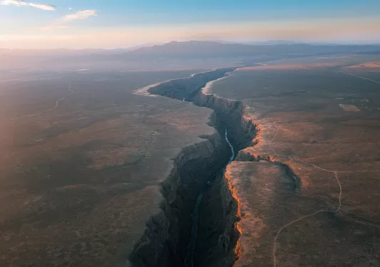 Long river in between tall canyons and plateaus of land