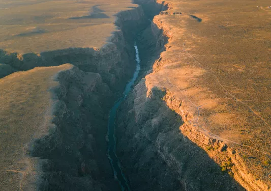 Long river in between tall canyons and plateaus of land