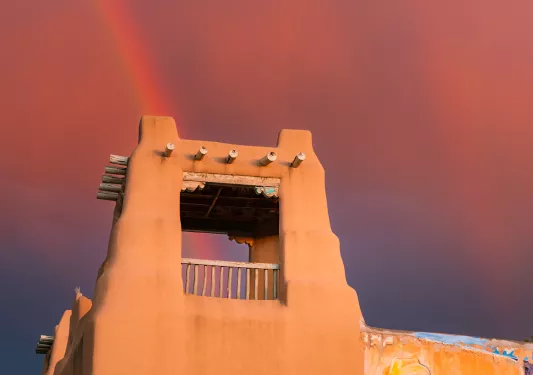 Clay building with wooden balconies with a pink sky