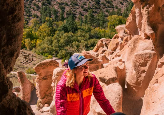 Woman smiling while climbing stairs into a cave