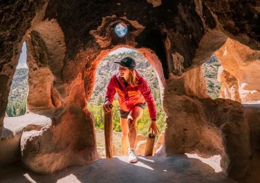 Woman climbing into a stone cave