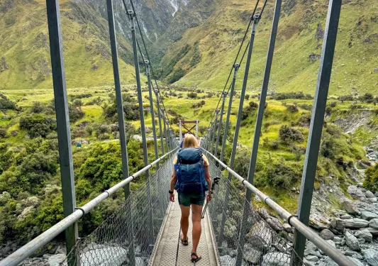 Woman walking on a wooden bridge over a river