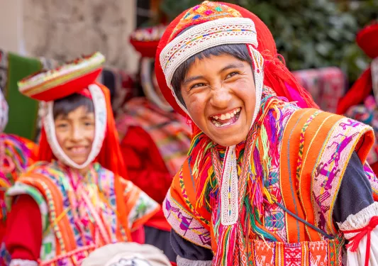 Boy in traditional attire, smiling with a group of other boys behind him