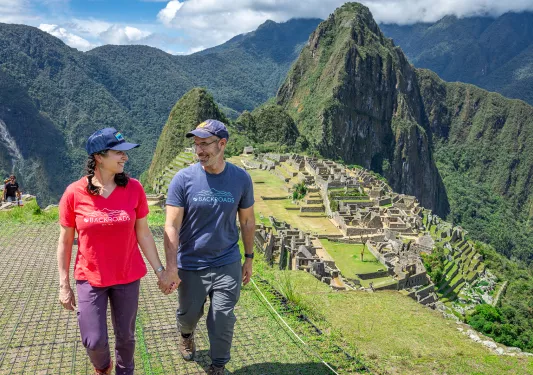Man and women holding hands, with sights of Machu Picchu in the background