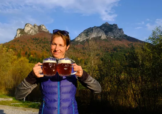 Backroads guests poses with two jugs of beer