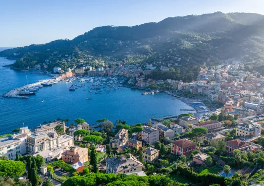 Sky view of large lake surrounded by a town of houses and mountains