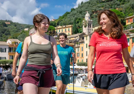 Two women smiling while walking along a boat dock