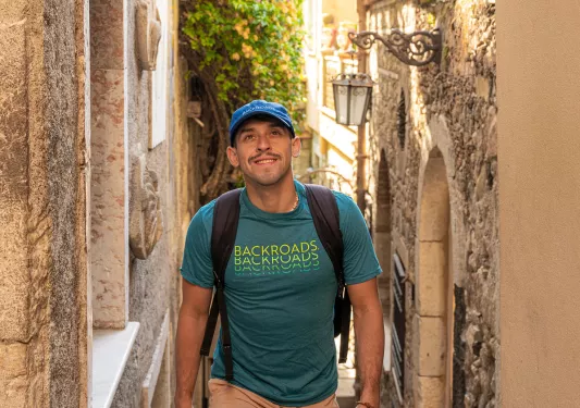 Man smiling while walking up stairs in an alleyway