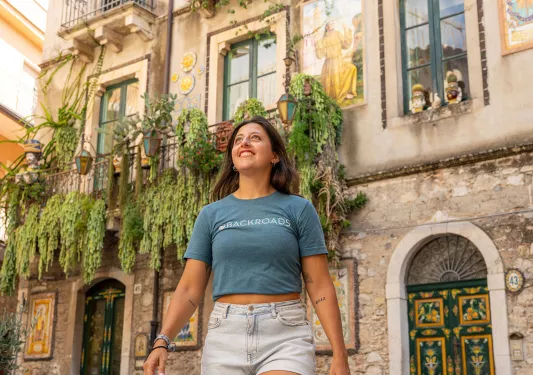 Woman smiling while looking up, with a stone building in the background