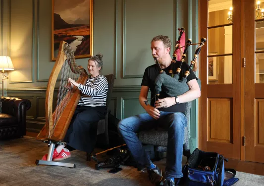 Man playing bagpipes and woman playing a harp