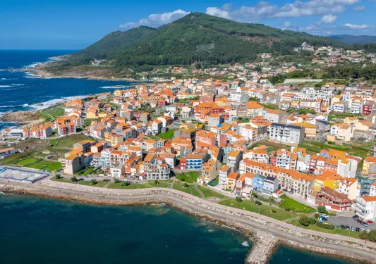 Sky view of town with houses and apartments, surrounded by the ocean