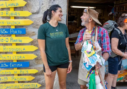 Man and woman smiling next to yellow and blue arrow signs